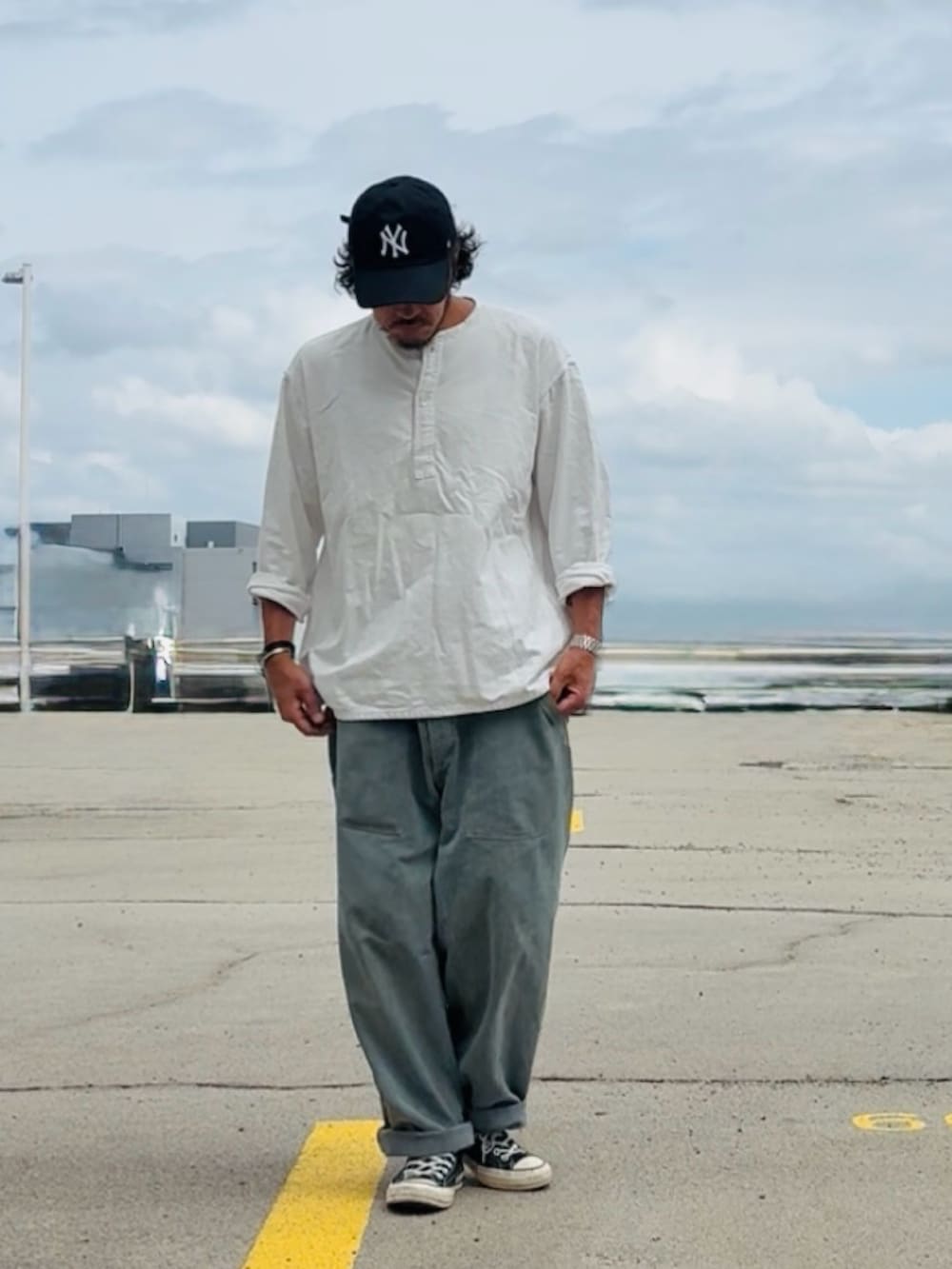 ホワイト系のTシャツ/カットソー、グレー系のデニムパンツ、ブラック系のスニーカーを着用したメンズの夏コーディネートの2枚目の写真