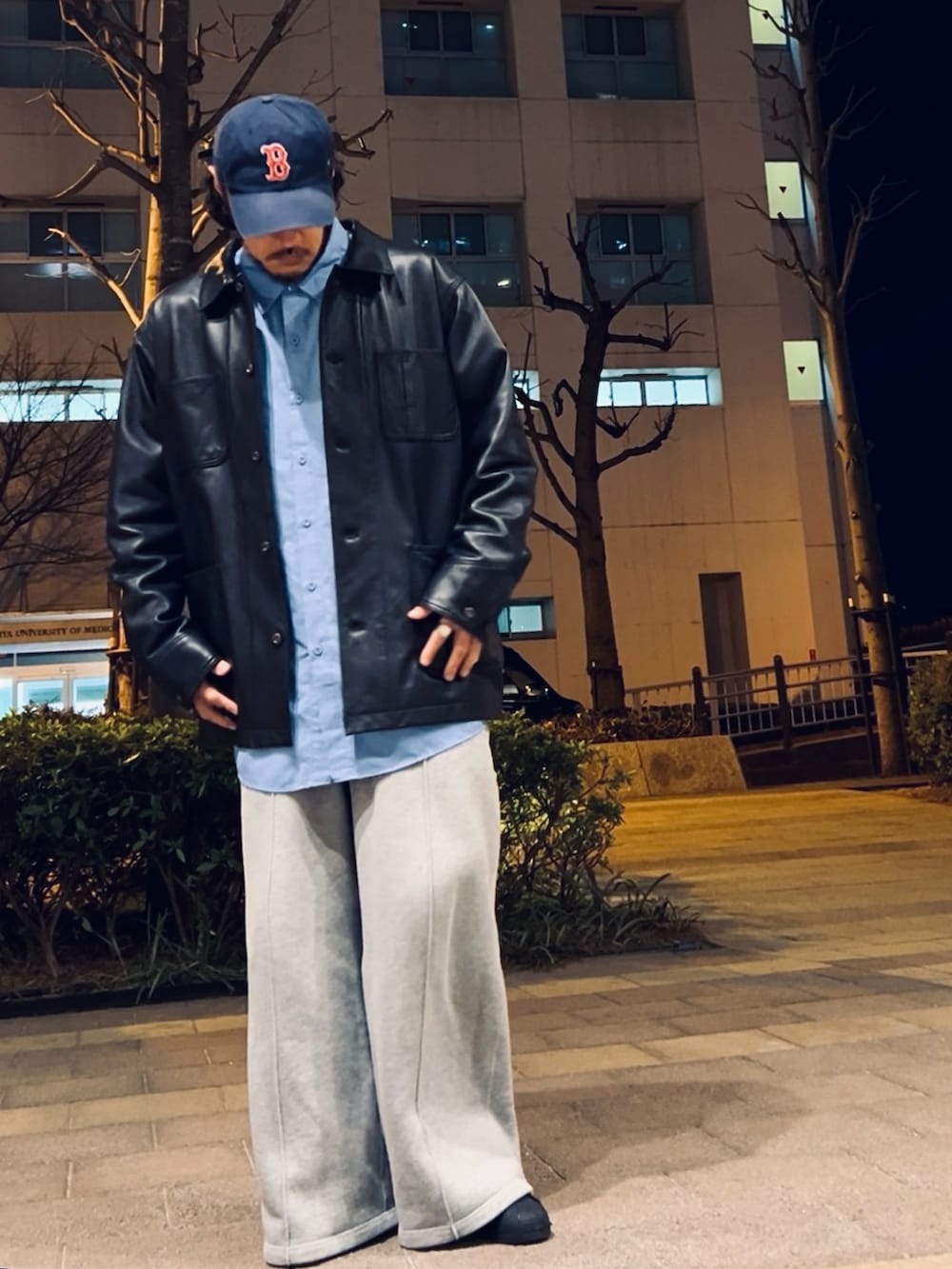 ブラック系のスニーカー、ブラック系のライダースジャケット、ブルー系のシャツ/ブラウスを着用したメンズの春コーディネートの2枚目の写真