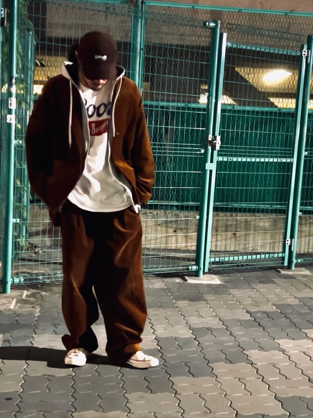 グレー系のスウェット、ホワイト系のTシャツ/カットソー、ブラウン系のセットアップを着用したメンズの冬コーディネートの2枚目の写真