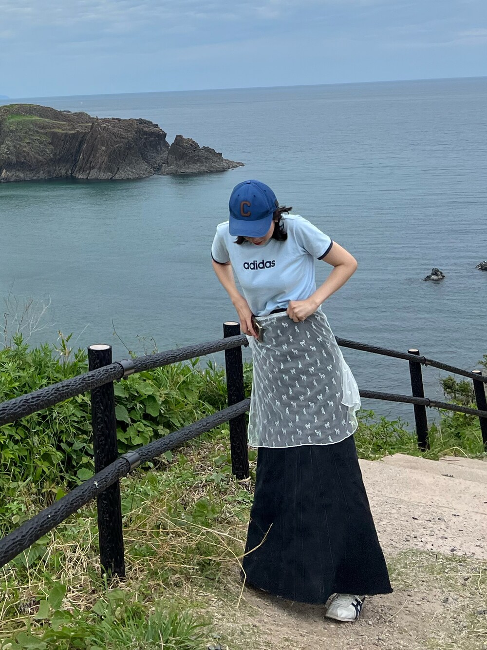 ブルー系のTシャツ/カットソー、ホワイト系のスカート、ブラック系のデニムスカートを着用したレディースの夏コーディネートの2枚目の写真