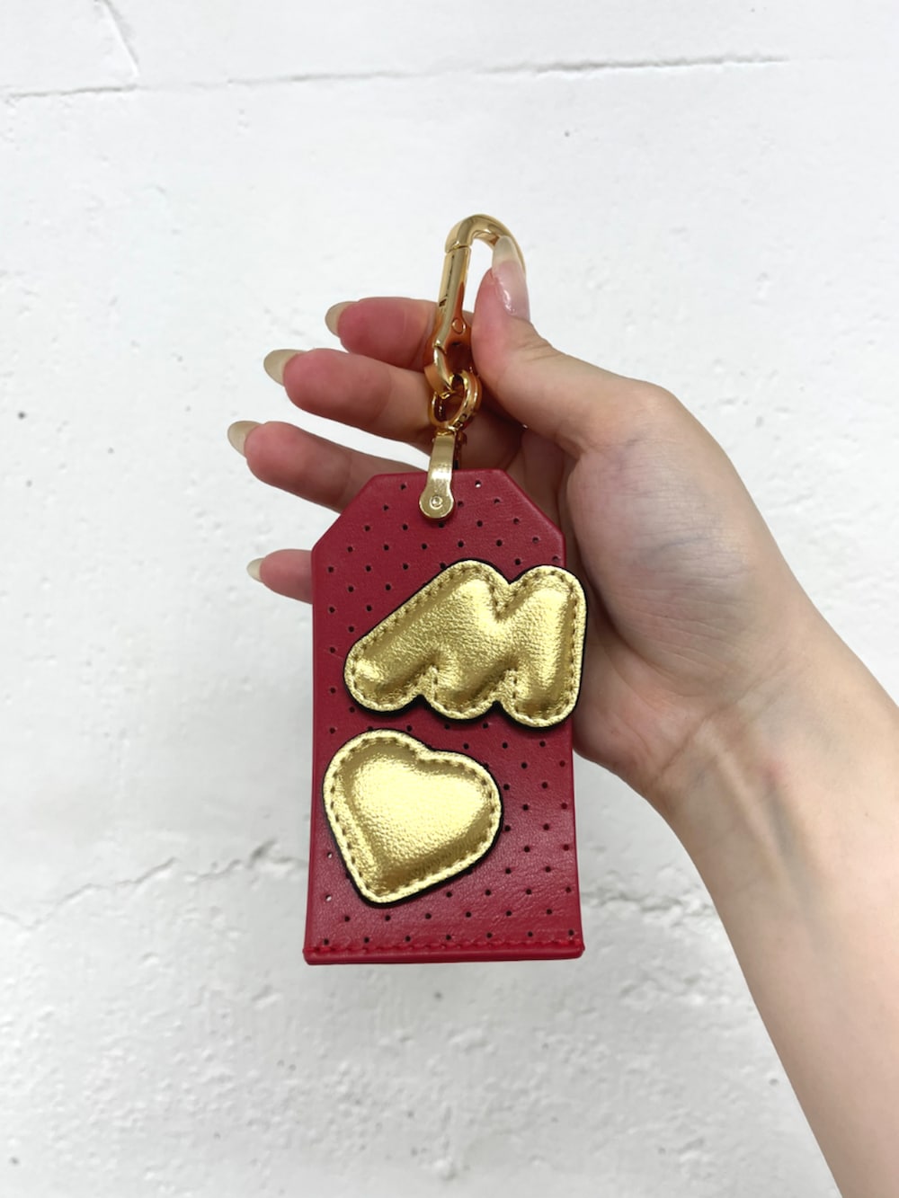 レッド系のキーホルダーを着用したレディースの冬コーディネートの2枚目の写真