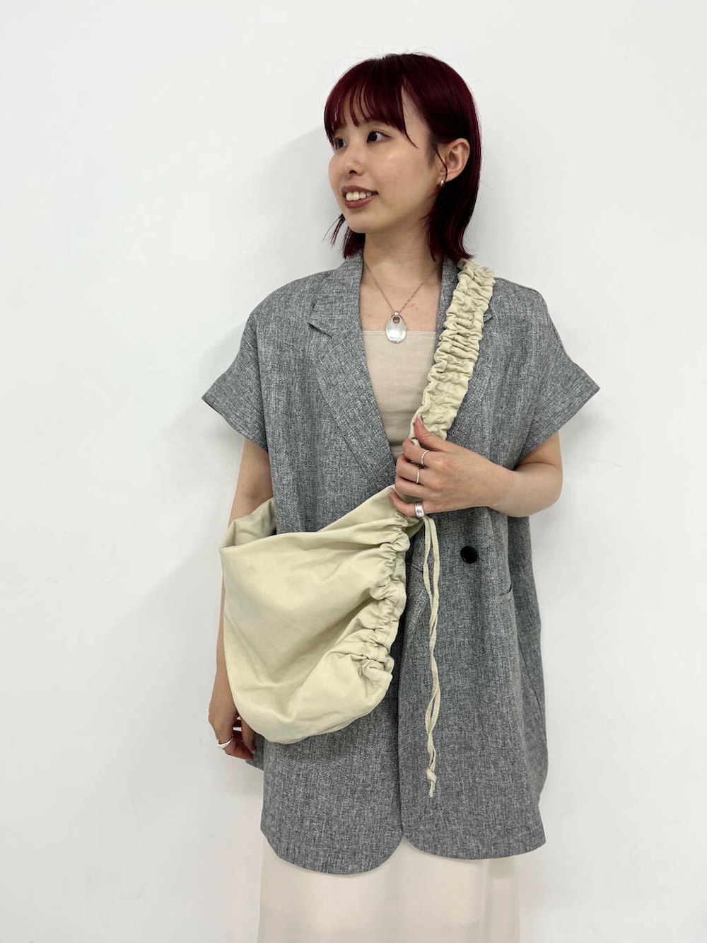 ホワイト系のスカート、ブラック系のサンダル、ホワイト系のショルダーバッグを着用したレディースの夏コーディネートの2枚目の写真