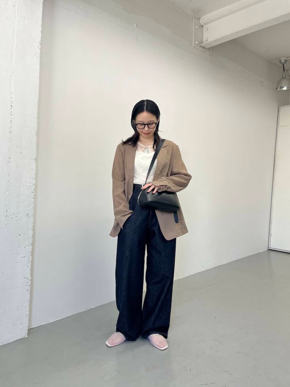 ブルー系のデニムパンツ、ホワイト系のバレエシューズ、ホワイト系のTシャツ/カットソーを着用したレディースの春コーディネートの2枚目の写真