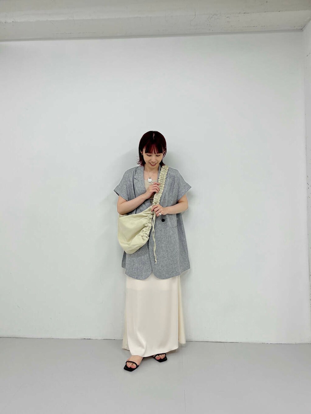 ホワイト系のスカート、ブラック系のサンダル、ホワイト系のショルダーバッグを着用したレディースの夏コーディネートの3枚目の写真