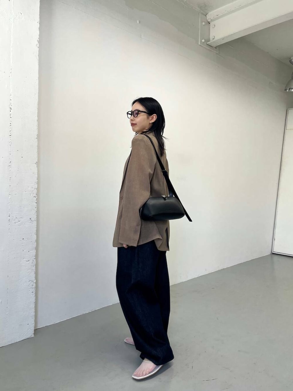 ブルー系のデニムパンツ、ホワイト系のバレエシューズ、ホワイト系のTシャツ/カットソーを着用したレディースの春コーディネートの3枚目の写真