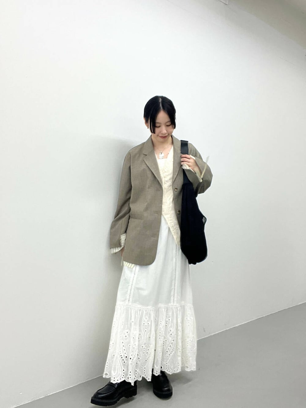 ブラック系のローファー、ベージュ系のその他アウター、ホワイト系のベストを着用したレディースの春コーディネートの3枚目の写真