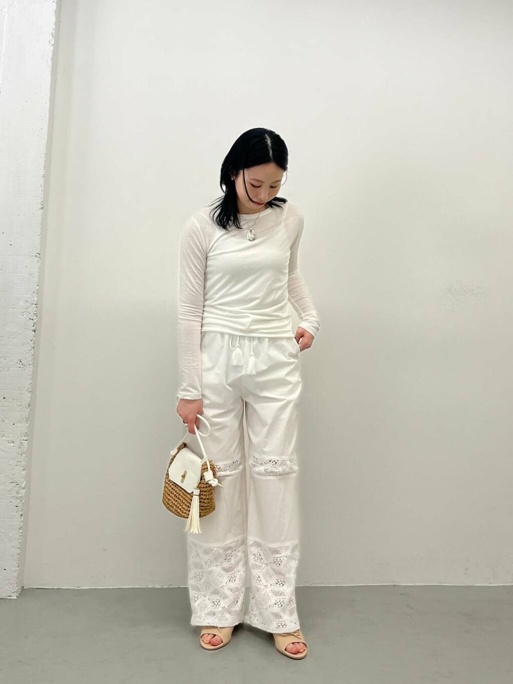 イエロー系のショルダーバッグ、ホワイト系のその他パンツ、ベージュ系のサンダルを着用したレディースの春コーディネートの2枚目の写真