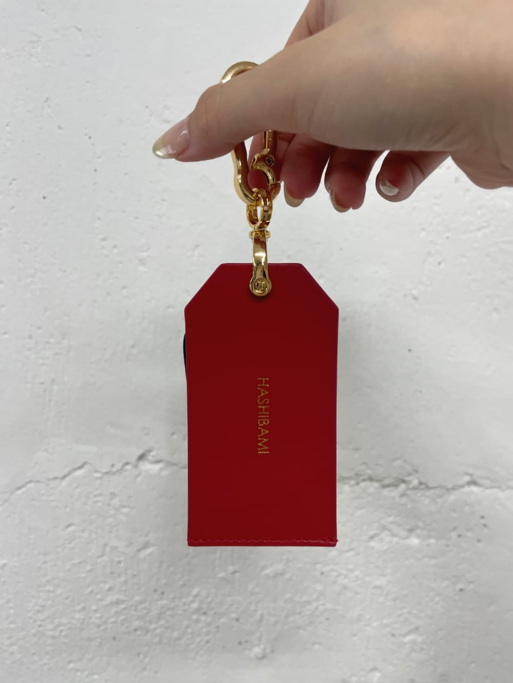 レッド系のキーホルダーを着用したレディースの冬コーディネートの3枚目の写真