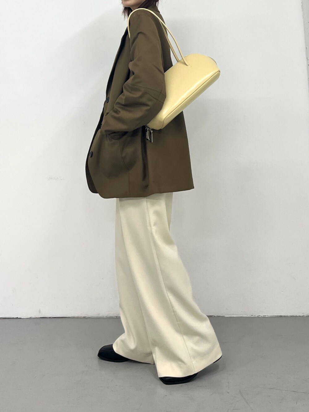 イエロー系のボストンバッグを着用したレディースの秋コーディネートの2枚目の写真