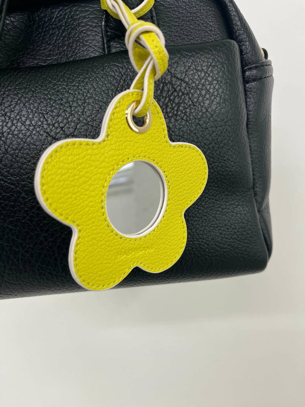 ブラック系のボストンバッグ、イエロー系のキーホルダー、ブラック系のキーホルダーを着用したレディースの夏コーディネートの3枚目の写真