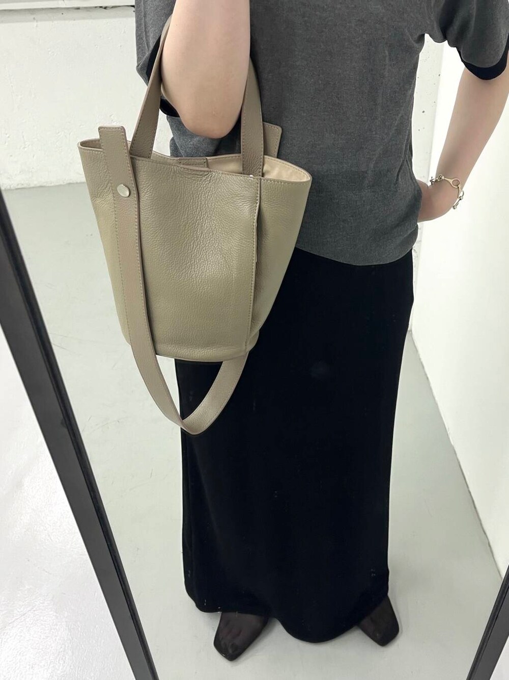 ベージュ系のショルダーバッグを着用したレディースの夏コーディネートの2枚目の写真