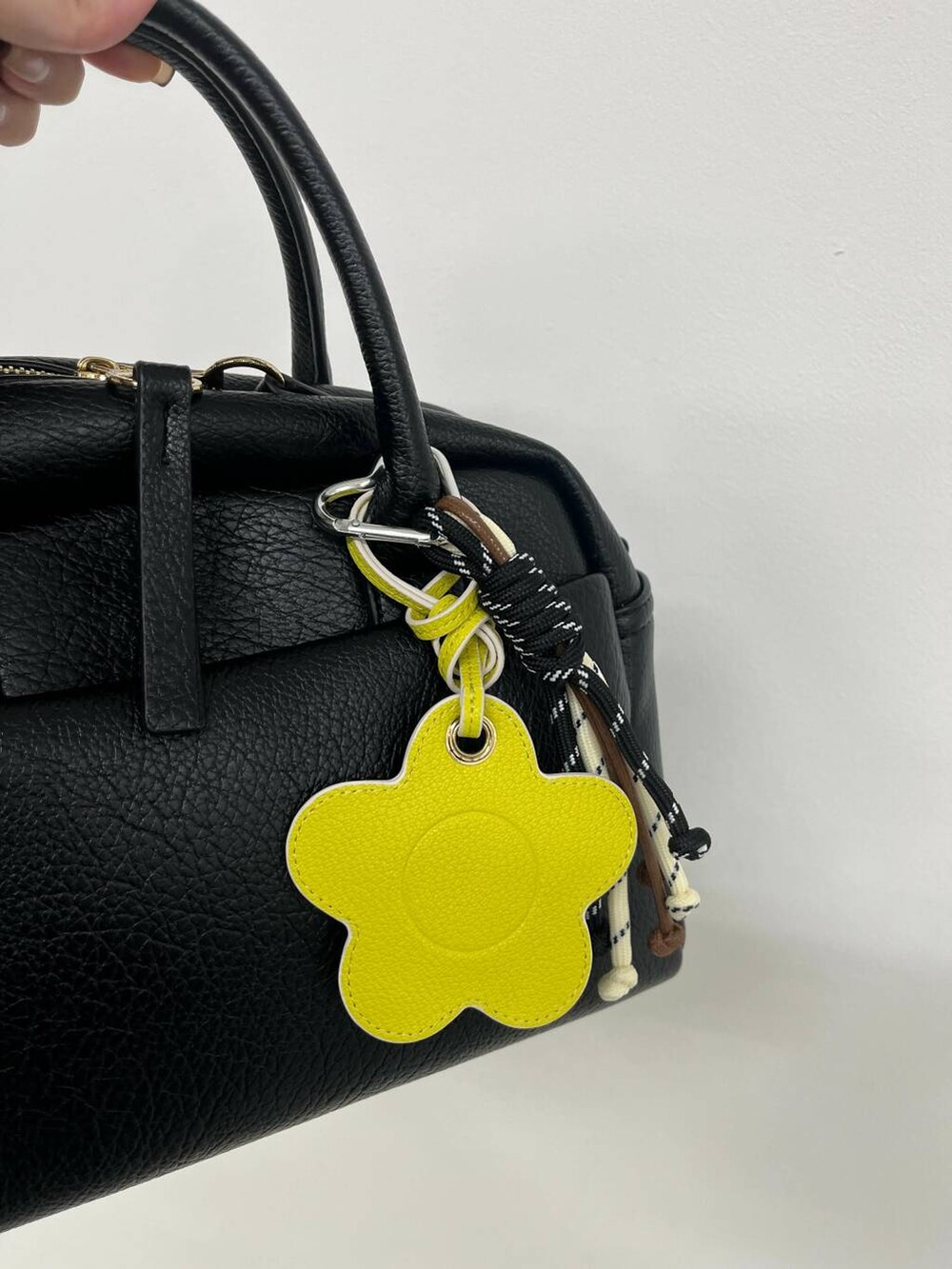 ブラック系のボストンバッグ、イエロー系のキーホルダー、ブラック系のキーホルダーを着用したレディースの夏コーディネートの2枚目の写真