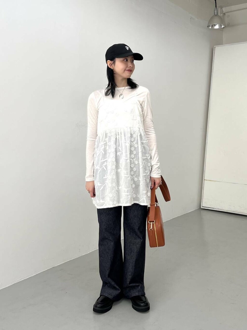 ブルー系のデニムパンツ、ブラック系のローファー、ホワイト系のTシャツ/カットソーを着用したレディースの春コーディネートの3枚目の写真