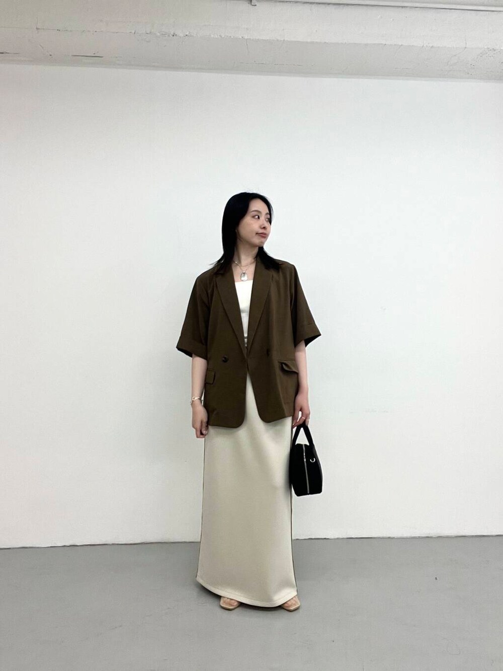 ブラウン系のその他アウター、ベージュ系のバレエシューズ、ブラック系のボストンバッグを着用したレディースの夏コーディネートの2枚目の写真
