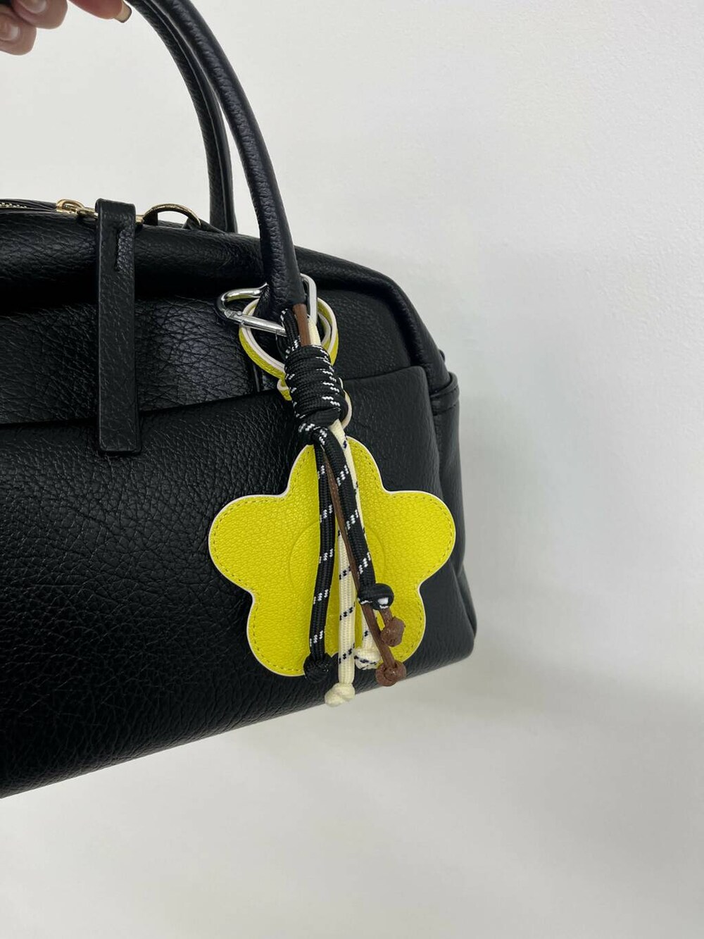 ブラック系のボストンバッグ、イエロー系のキーホルダー、ブラック系のキーホルダーを着用したレディースの夏コーディネートの4枚目の写真