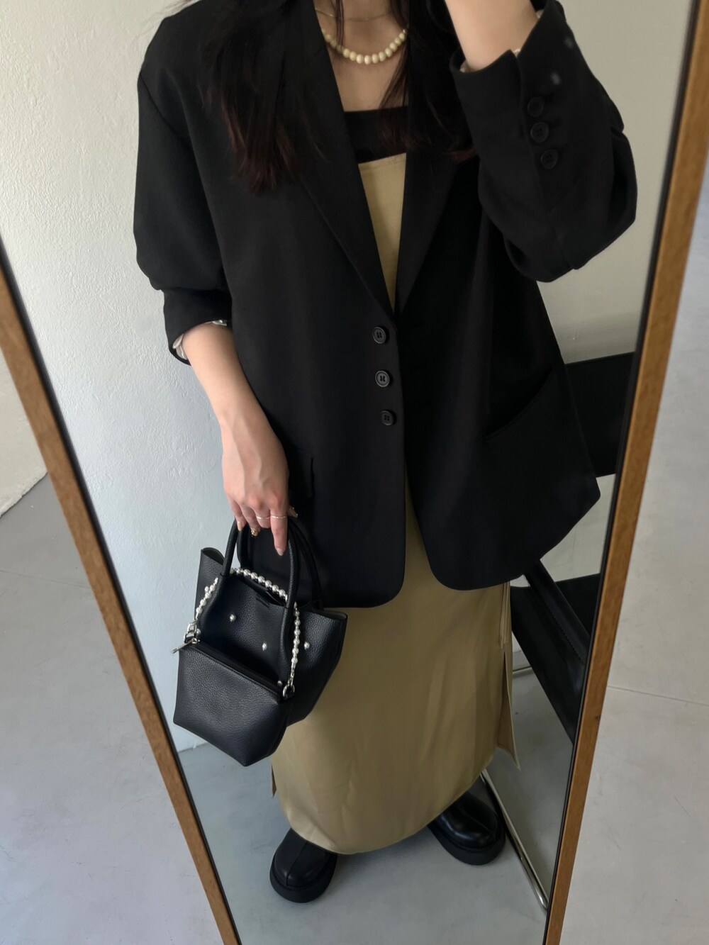 ブラック系のハンドバッグを着用したレディースの冬コーディネートの2枚目の写真