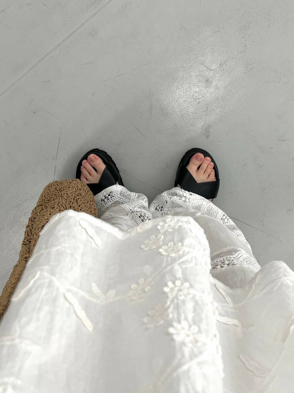 ベージュ系のトートバッグ、ブラック系のサンダル、ホワイト系のキャミソールを着用したレディースの春コーディネートの3枚目の写真