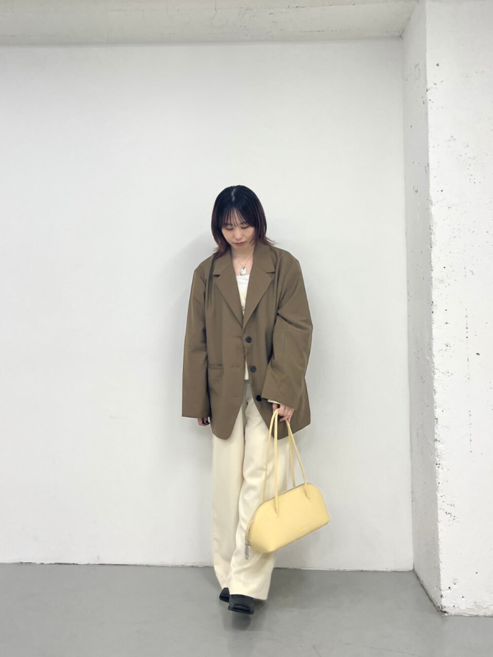 イエロー系のボストンバッグを着用したレディースの秋コーディネートの3枚目の写真