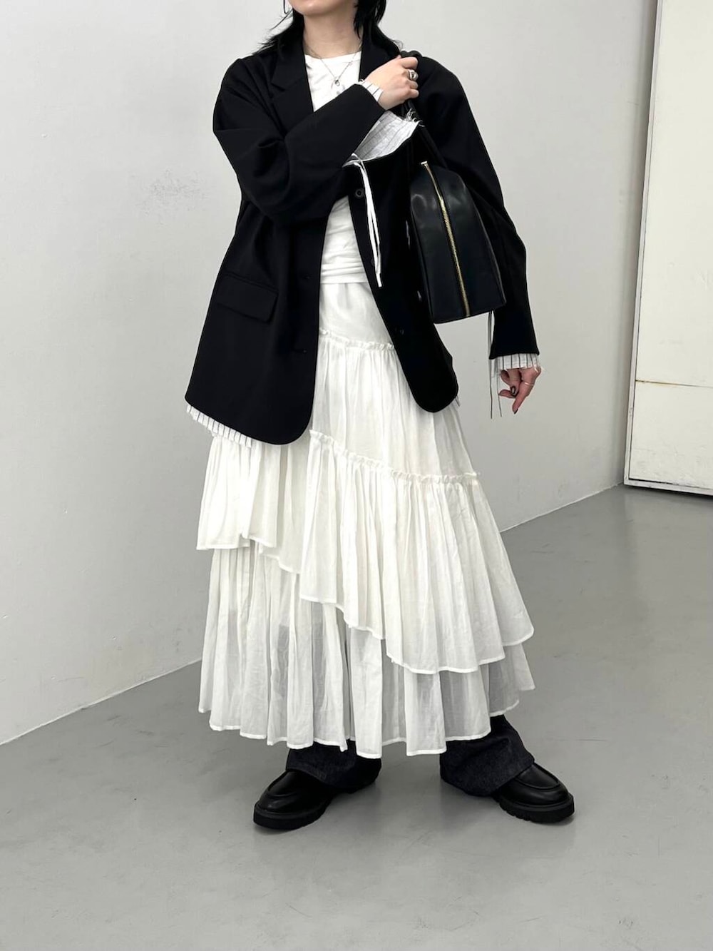 ブルー系のデニムパンツ、ブラック系のローファー、ブラック系のその他アウターを着用したレディースの春コーディネートの2枚目の写真