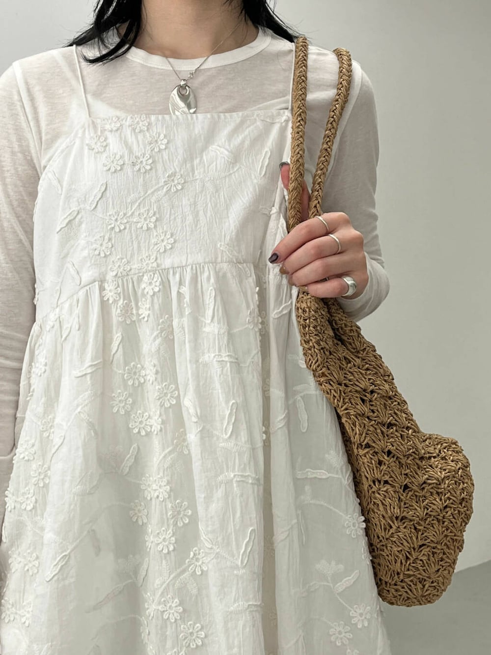 ベージュ系のトートバッグ、ブラック系のサンダル、ホワイト系のキャミソールを着用したレディースの春コーディネートの4枚目の写真