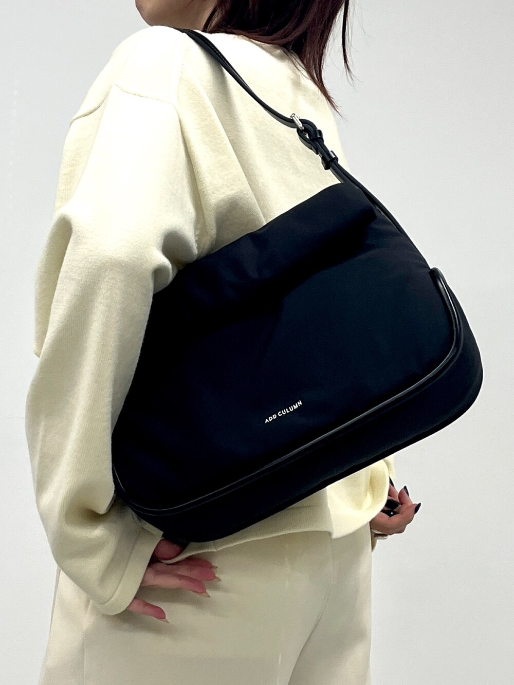 ブラック系のショルダーバッグを着用したレディースの冬コーディネートの3枚目の写真