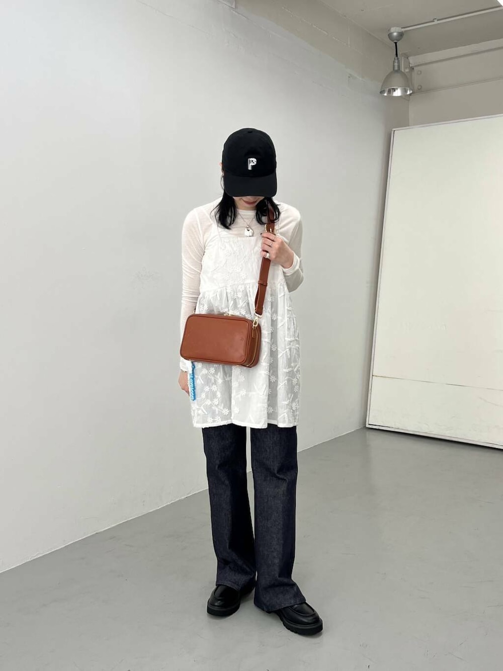 ブルー系のデニムパンツ、ブラック系のローファー、ホワイト系のTシャツ/カットソーを着用したレディースの春コーディネートの2枚目の写真