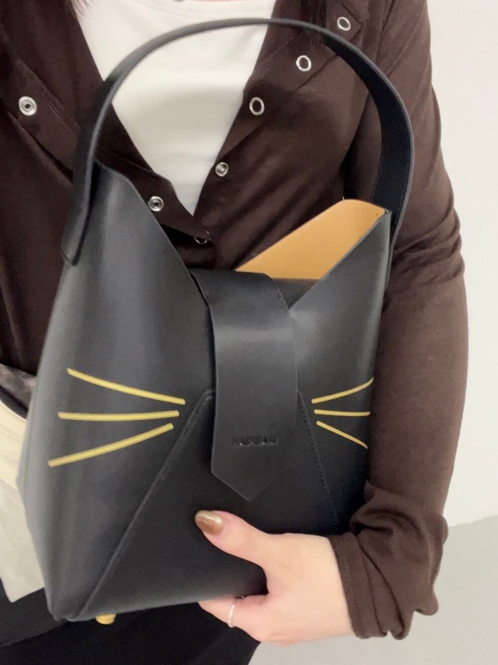 ブラック系のハンドバッグを着用したレディースの夏コーディネートの4枚目の写真