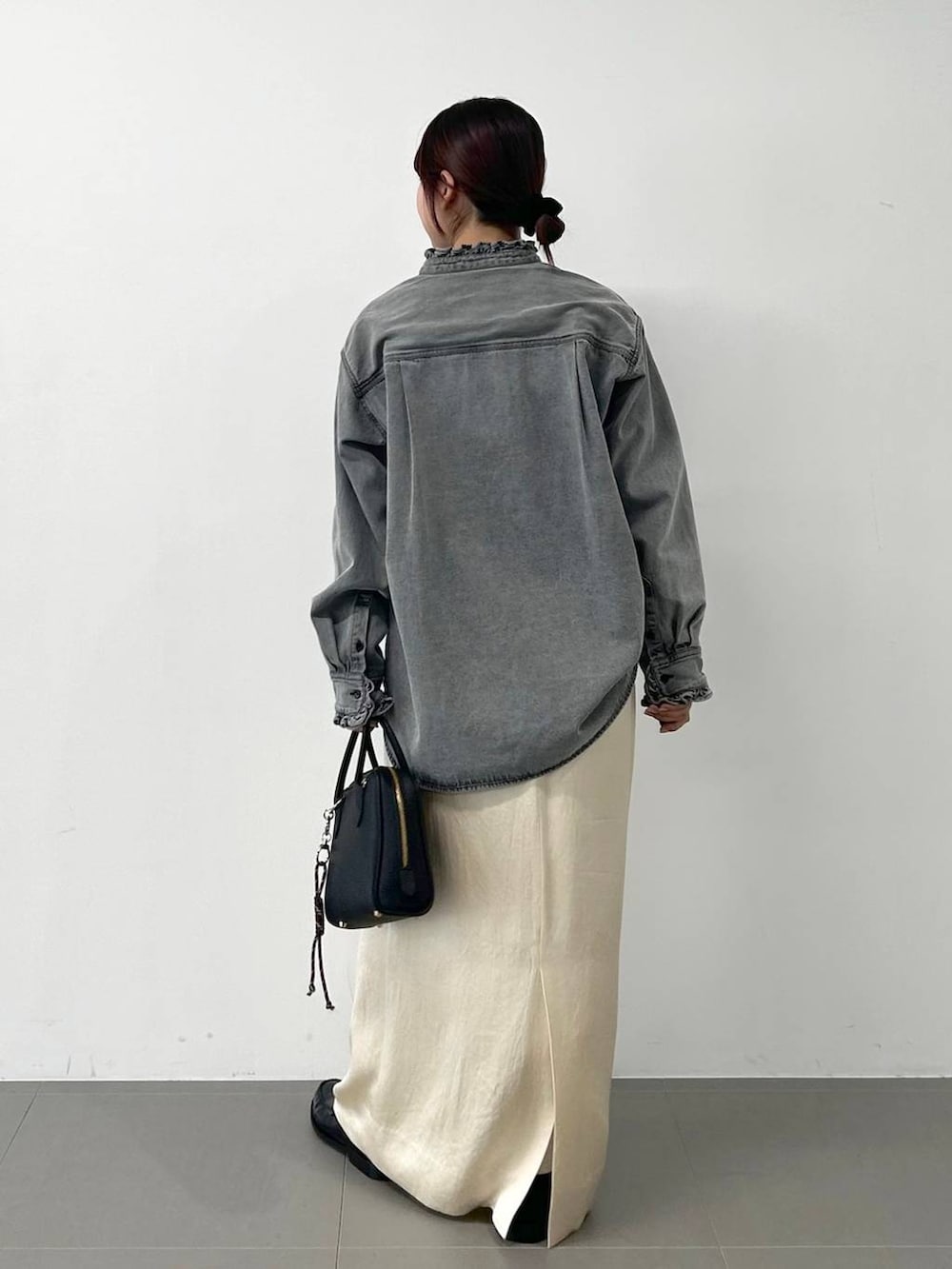 グレー系のシャツ/ブラウス、ホワイト系のスカートを着用したレディースの冬コーディネートの3枚目の写真