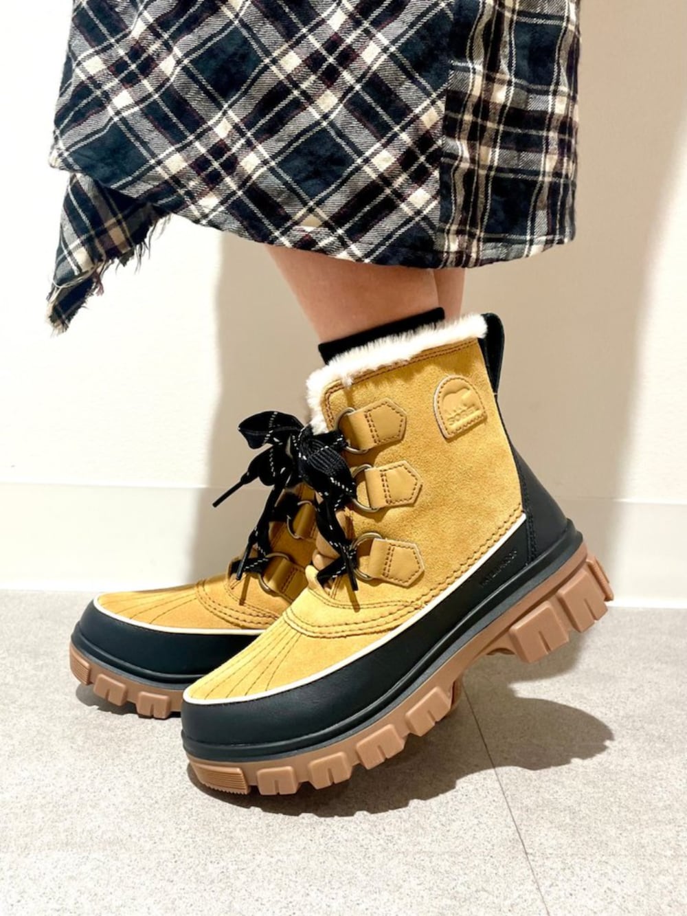 イエロー系のブーツを着用したレディースの冬コーディネートの3枚目の写真