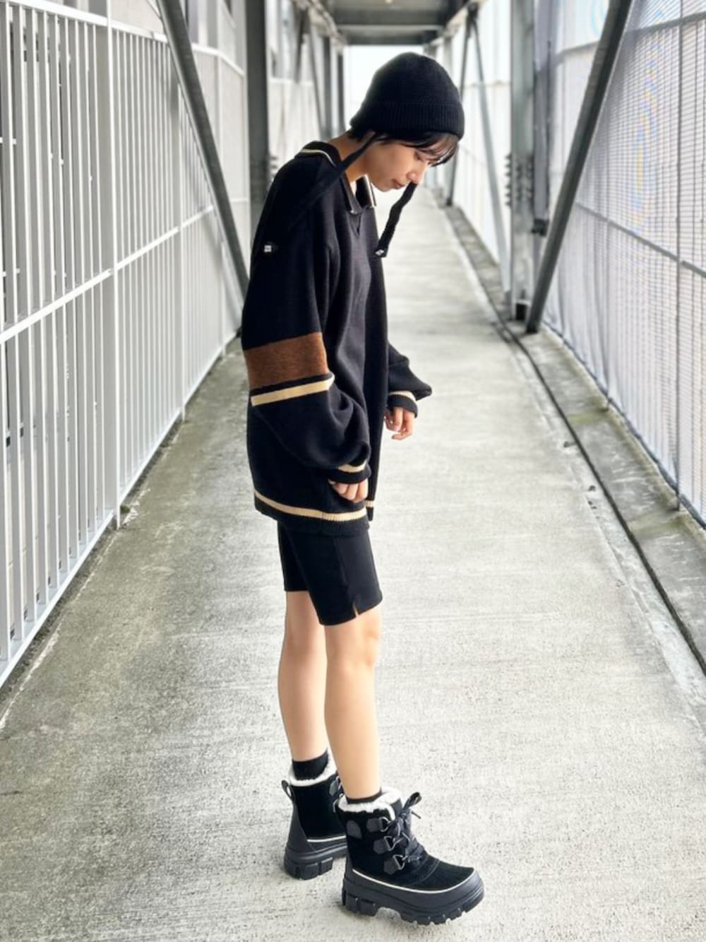 ブラック系のブーツを着用したレディースの秋コーディネートの2枚目の写真