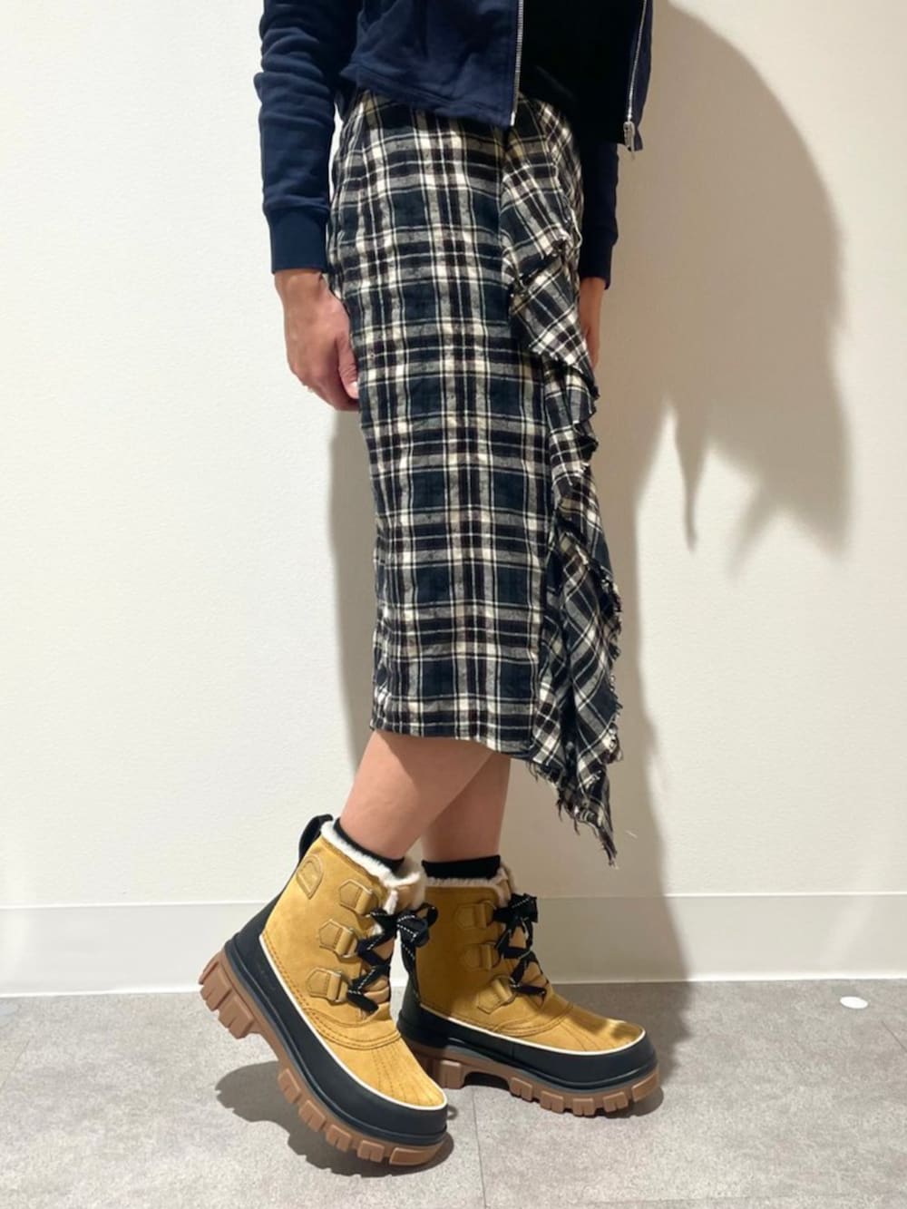 イエロー系のブーツを着用したレディースの冬コーディネートの2枚目の写真
