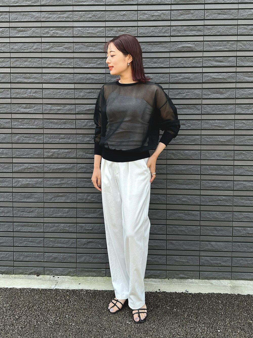 ブラック系のニット/セーター、ホワイト系のその他パンツ、ブラック系のサンダルを着用したレディースの春コーディネートの2枚目の写真