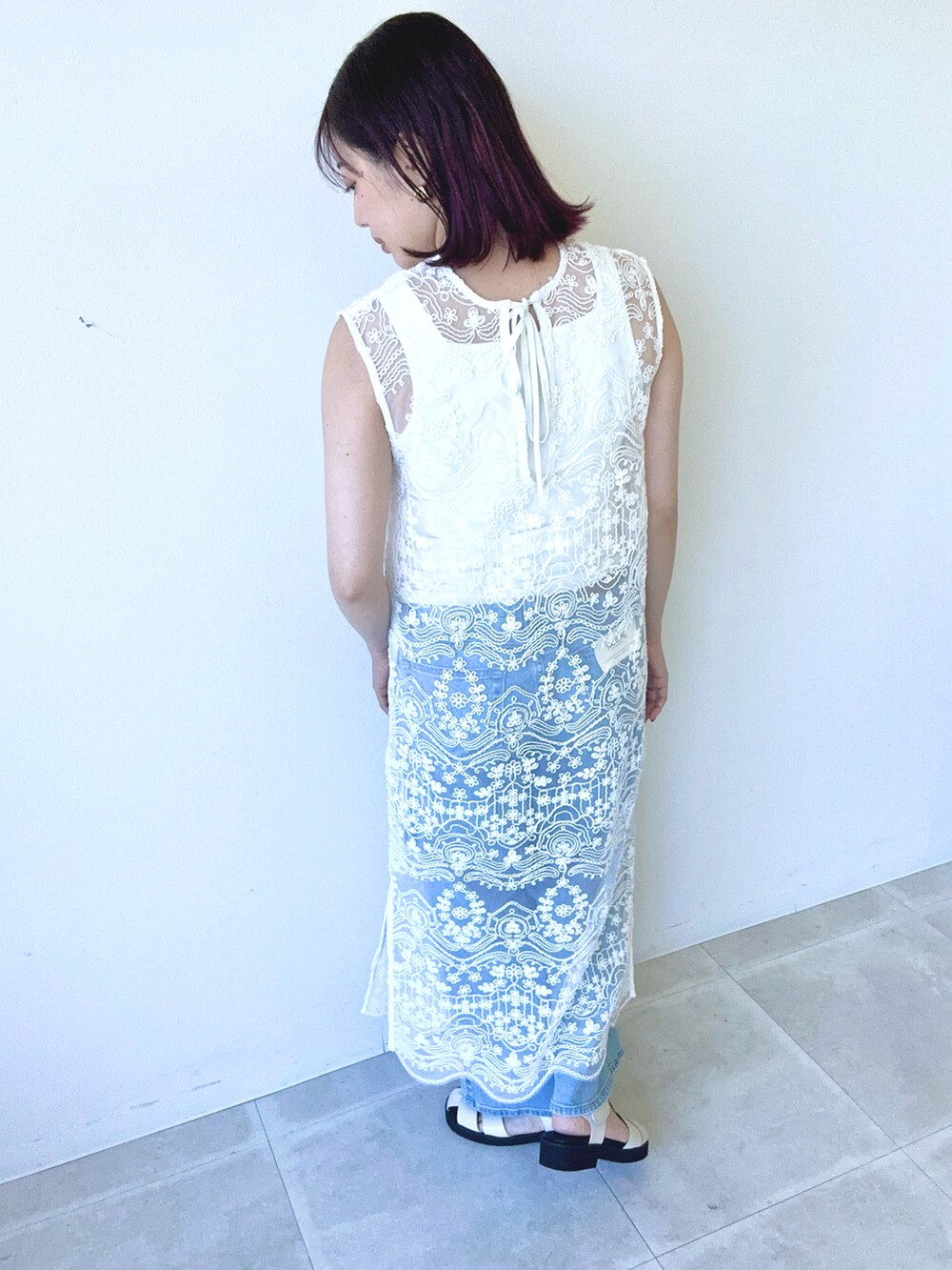 ホワイト系のワンピース、ホワイト系のタンクトップ、ブルー系のデニムパンツを着用したレディースの春コーディネートの3枚目の写真