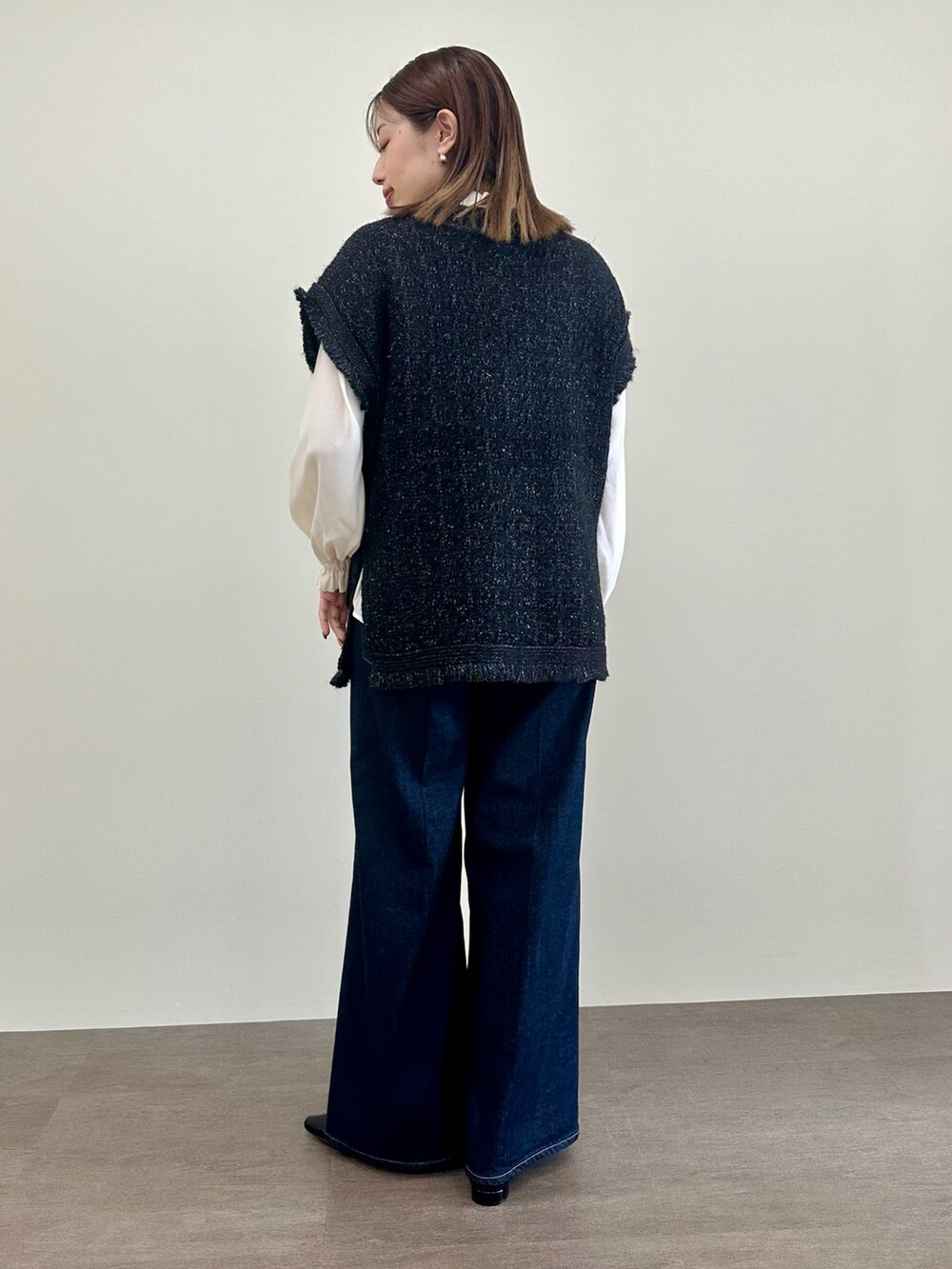 ブラック系のニット/セーター、ホワイト系のシャツ/ブラウス、ブルー系のデニムパンツを着用したレディースの夏コーディネートの3枚目の写真