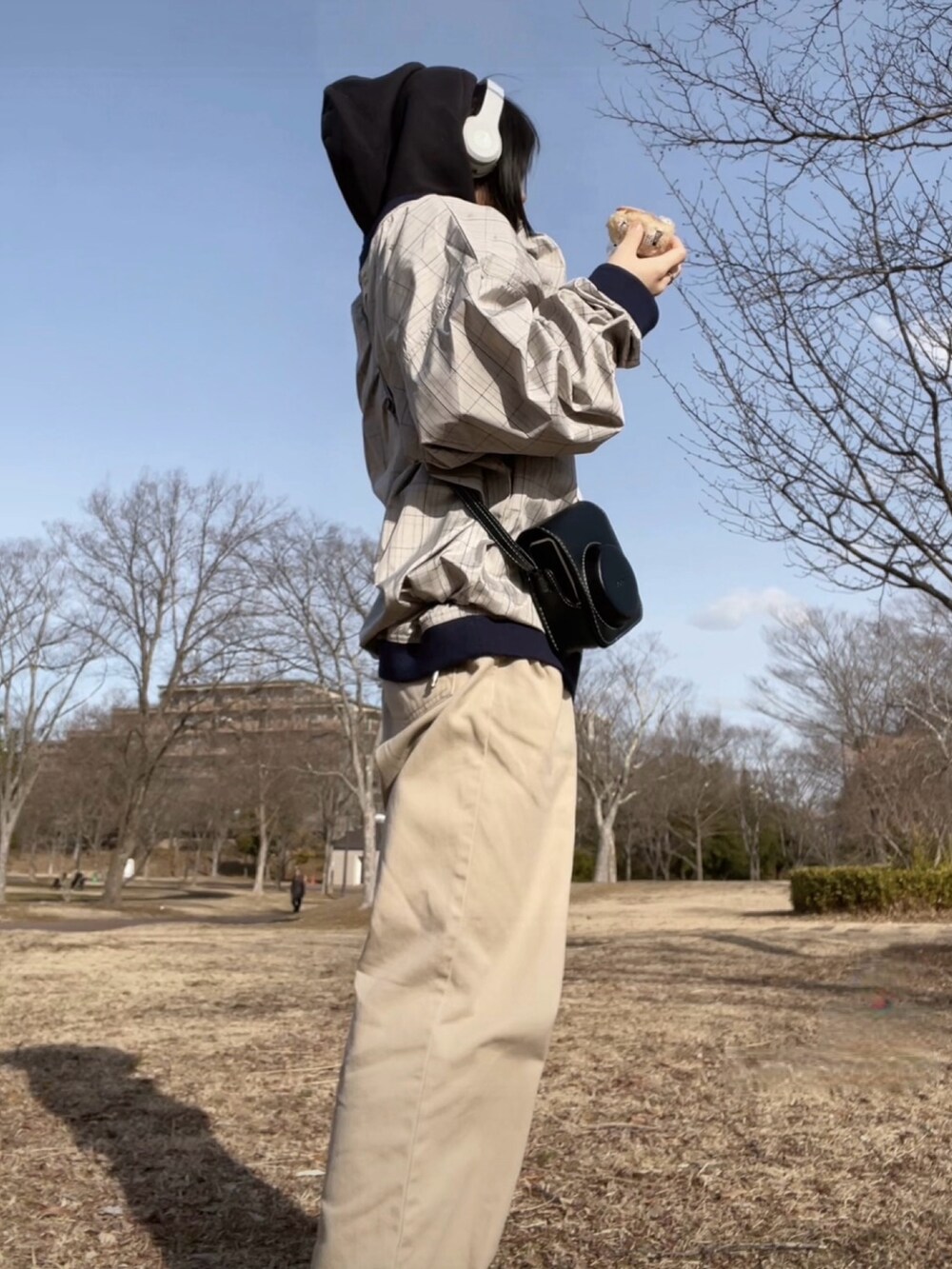 レッド系のスリッポン、ベージュ系のパンツ、グレー系のナイロンジャケットを着用したレディースの春コーディネートの4枚目の写真