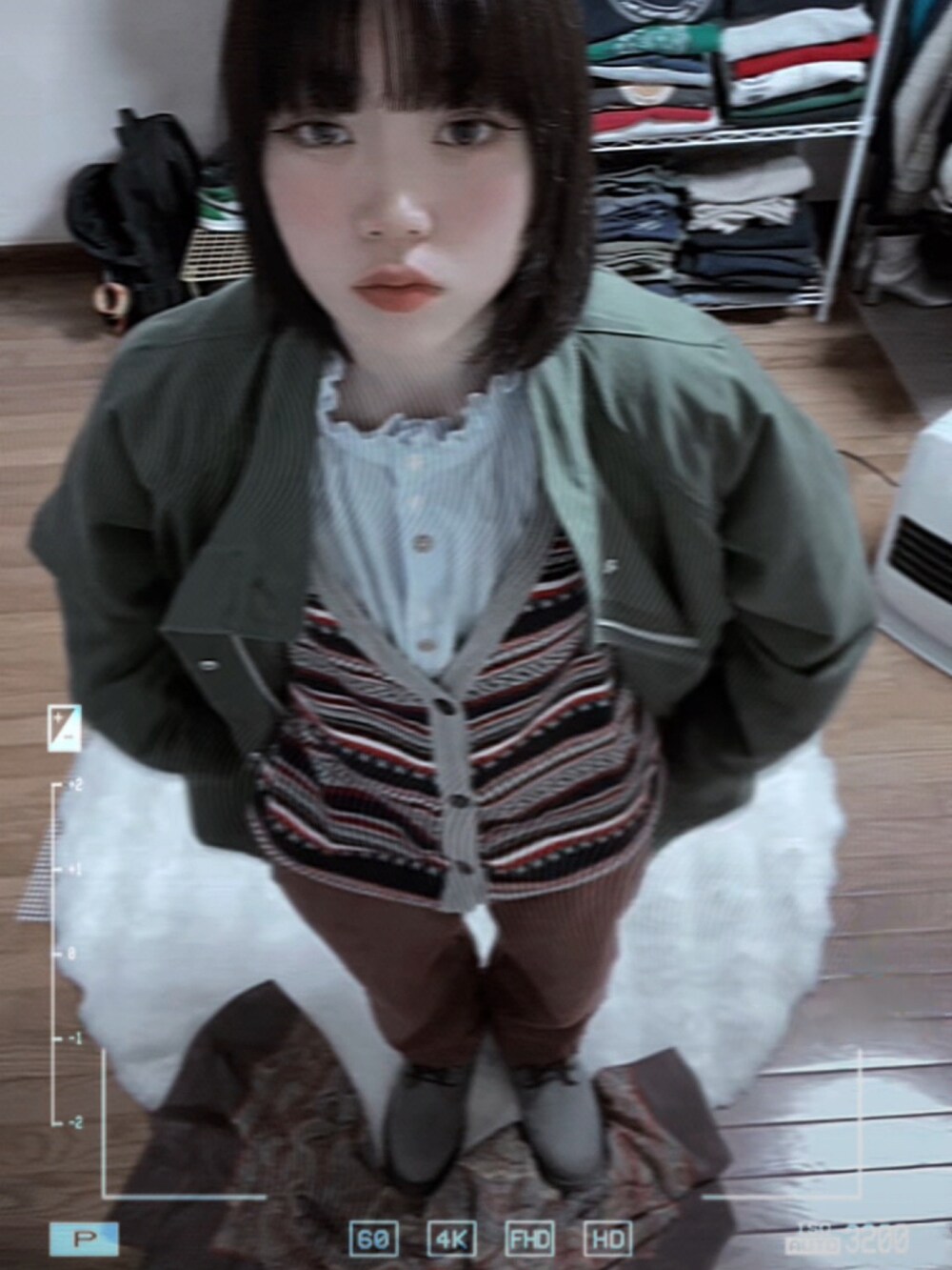 グリーン系のミリタリージャケット、ブルー系のシャツ/ブラウス、その他のカーディガン/ボレロを着用したレディースの春コーディネートの2枚目の写真