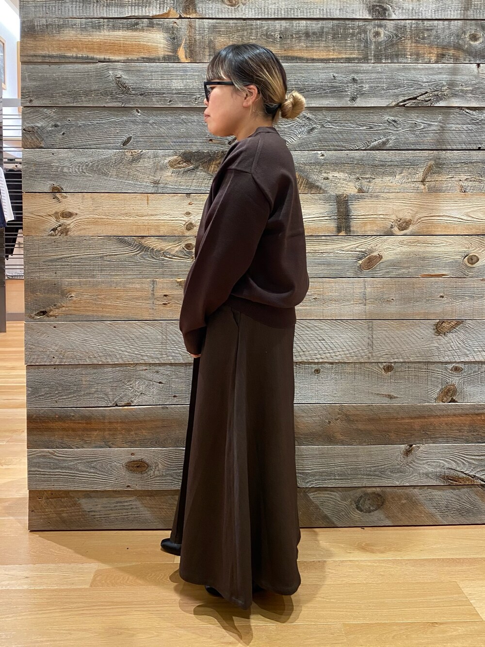 ブラウン系のニット/セーターを着用したレディースの秋コーディネートの2枚目の写真