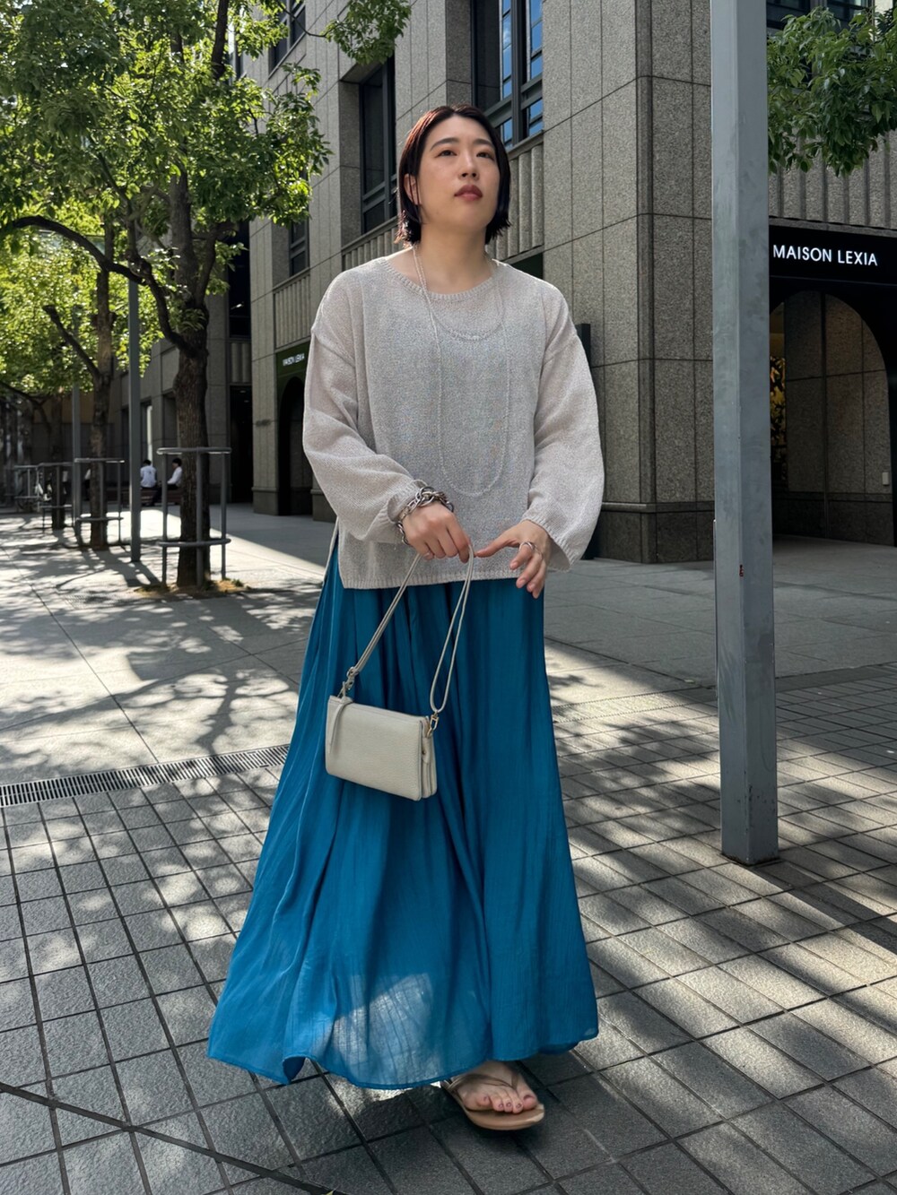 ブルー系のワンピース、ベージュ系のニット/セーター、ホワイト系のショルダーバッグを着用したレディースの夏コーディネートの6枚目の写真