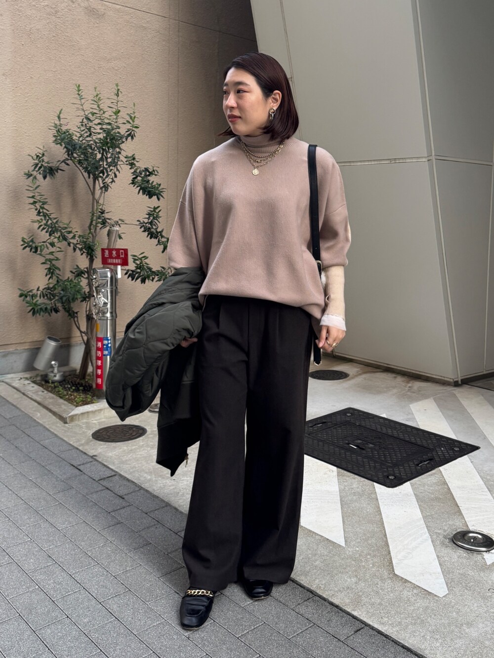 グリーン系のその他アウター、ベージュ系のニット/セーター、ブラウン系のその他パンツを着用したレディースの冬コーディネートの9枚目の写真