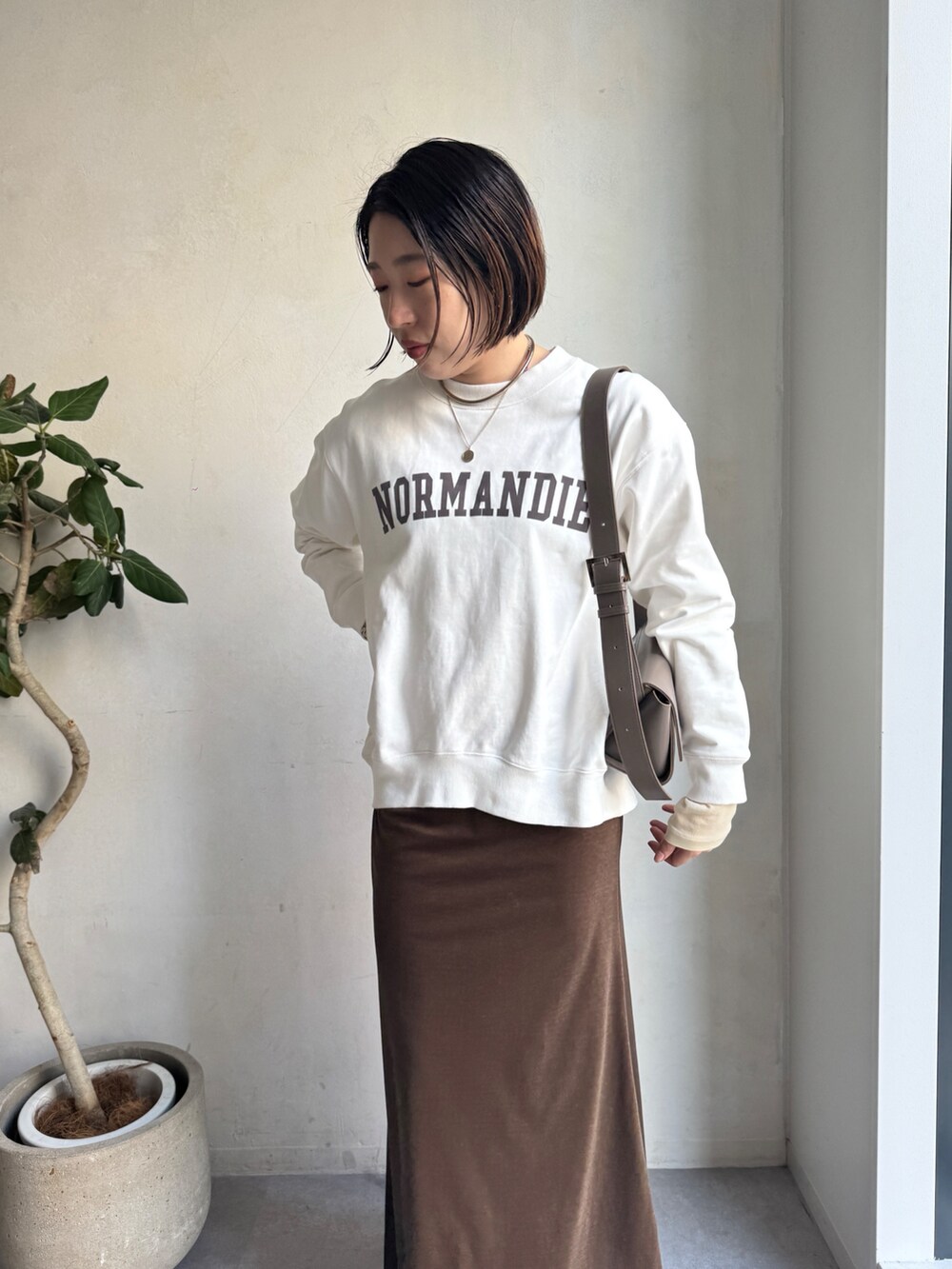 ベージュ系のその他アウター、ブラウン系のスカート、ホワイト系のTシャツ/カットソーを着用したレディースの冬コーディネートの8枚目の写真