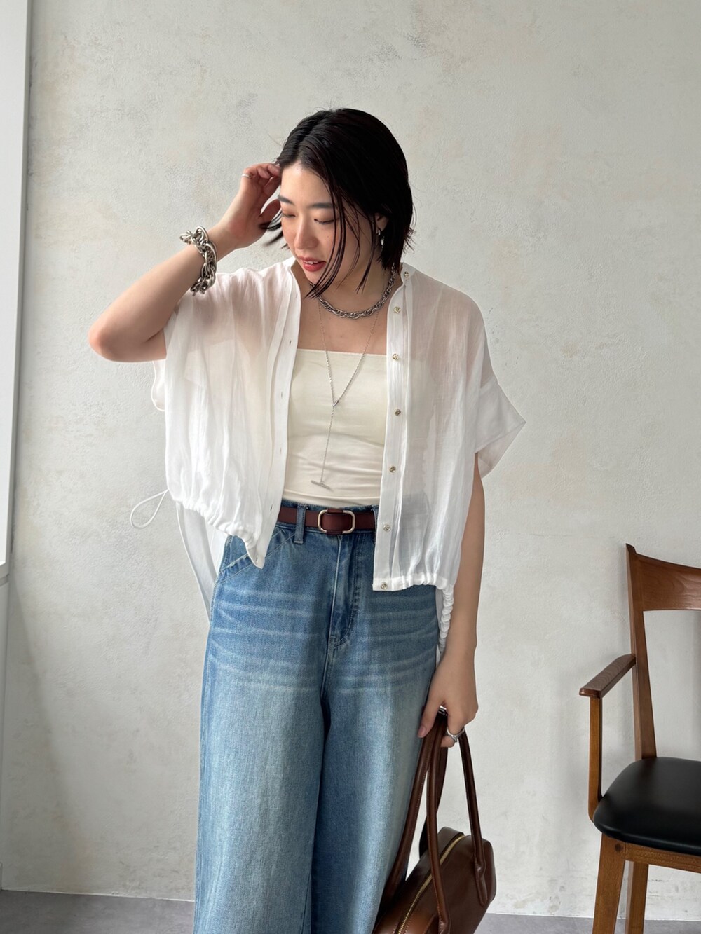 ブルー系のデニムパンツ、ホワイト系のシャツ/ブラウスを着用したレディースの夏コーディネートの6枚目の写真