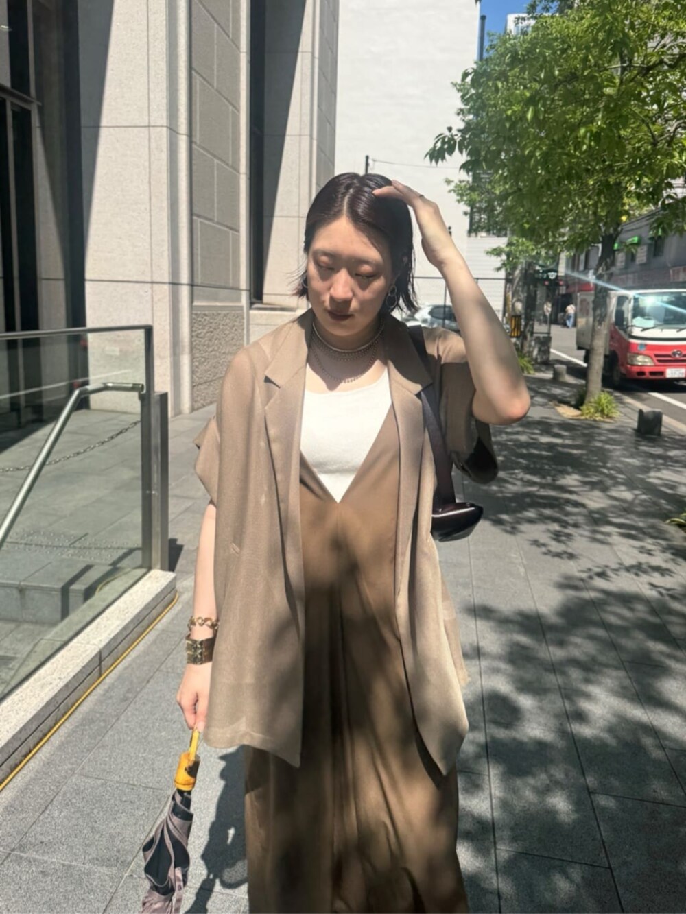 ホワイト系のタンクトップ、ブラウン系のテーラードジャケット、ベージュ系のワンピースを着用したレディースの夏コーディネートの7枚目の写真