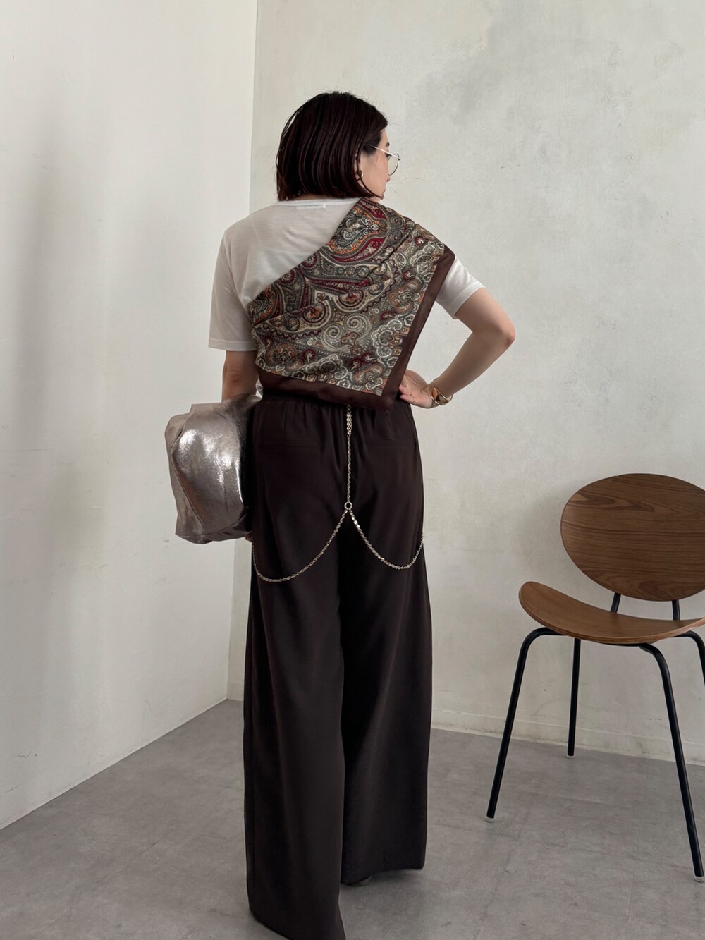 ホワイト系のTシャツ/カットソー、ブラウン系のスラックス、ブラウン系のストール/ショールを着用したレディースの夏コーディネートの2枚目の写真
