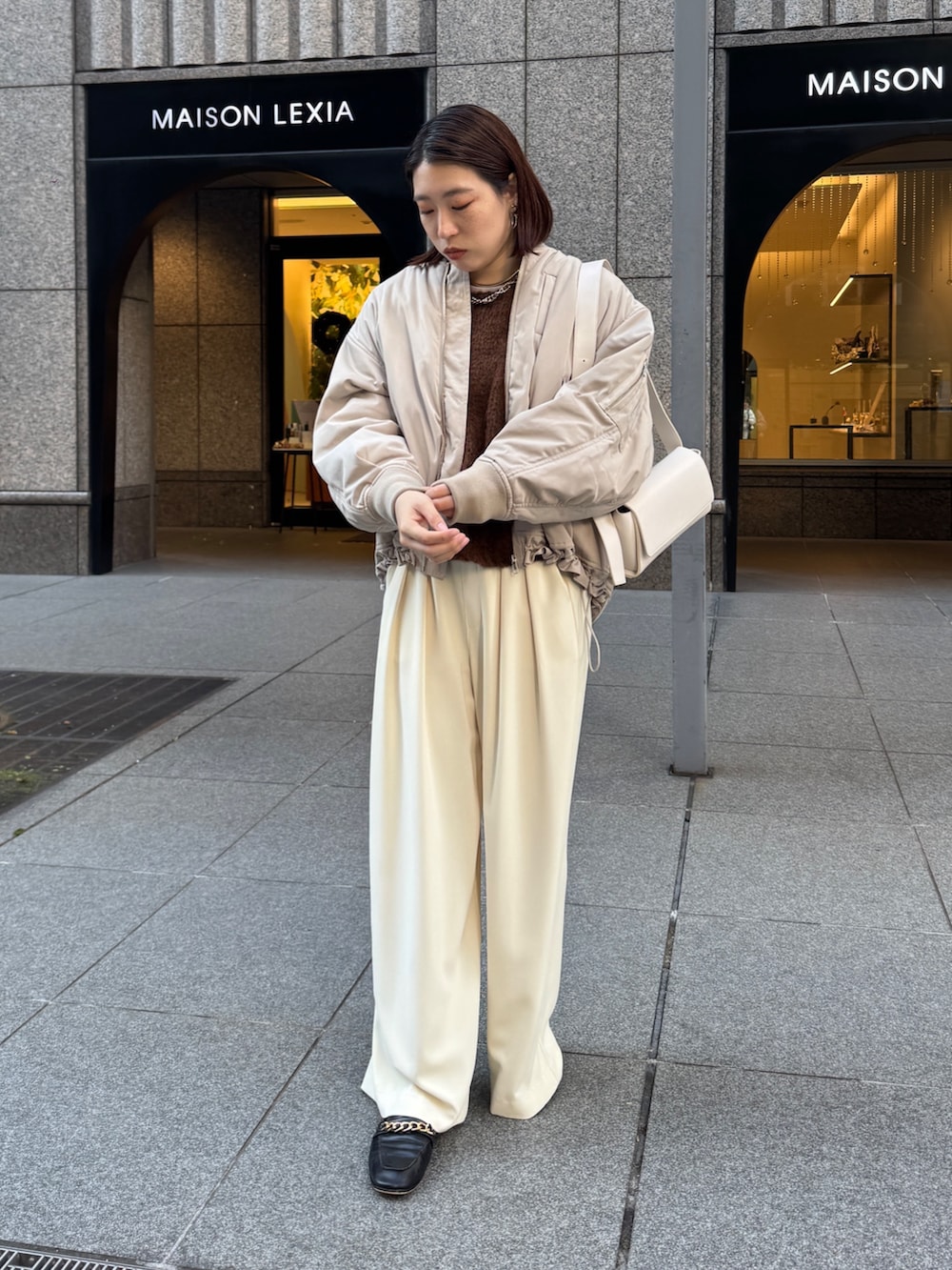 イエロー系のスラックス、ベージュ系のMA-1、ブラウン系のニット/セーターを着用したレディースの秋コーディネートの3枚目の写真