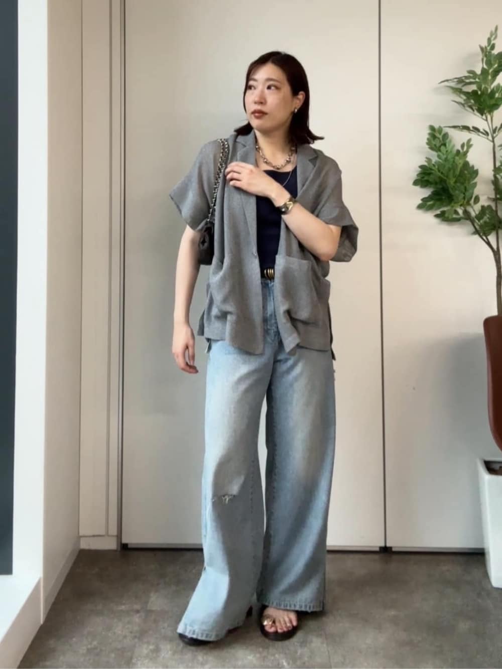 ブルー系のタンクトップ、ブルー系のデニムパンツ、ブラウン系のサンダルを着用したレディースの夏コーディネートの3枚目の写真