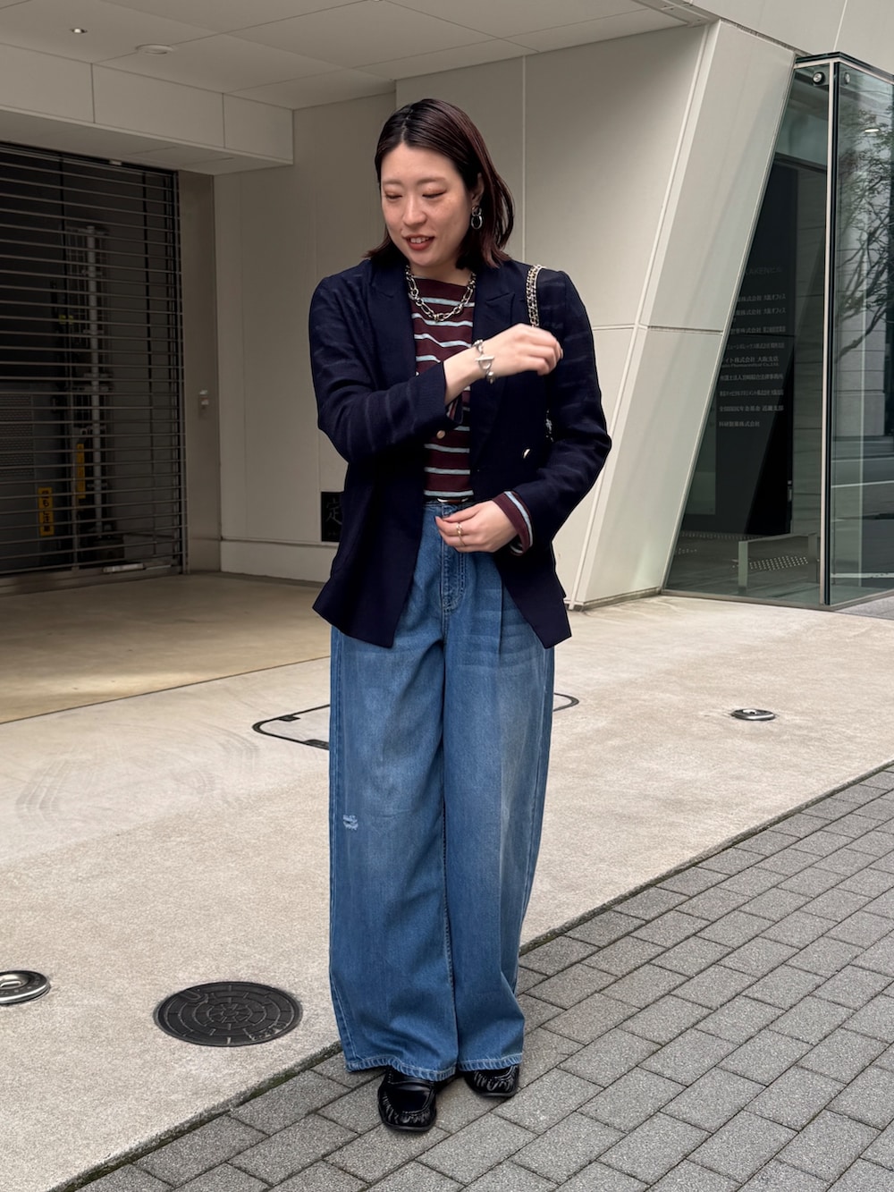 ブルー系のデニムパンツ、ブルー系のテーラードジャケット、ブラウン系のTシャツ/カットソーを着用したレディースの春コーディネートの4枚目の写真