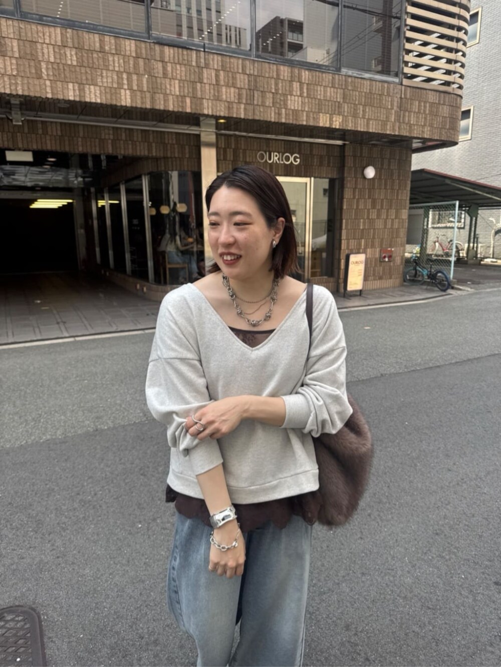 ブルー系のデニムパンツ、ブラウン系のパンプス、ブラウン系のシャツ/ブラウスを着用したレディースの夏コーディネートの6枚目の写真