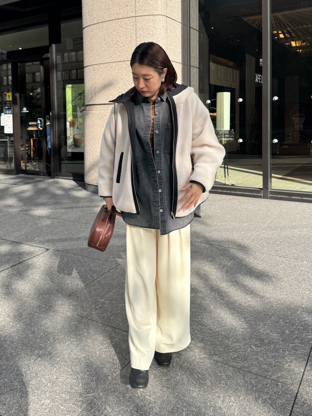 ホワイト系のその他アウター、ブルー系のシャツ/ブラウス、ブラウン系のTシャツ/カットソーを着用したレディースの秋コーディネートの4枚目の写真