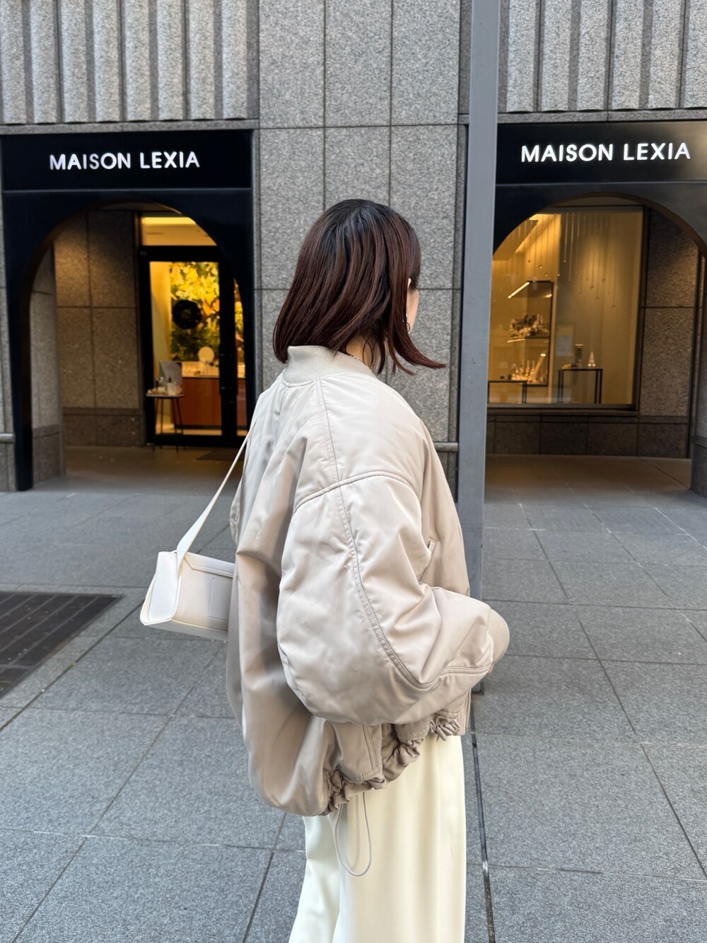 イエロー系のスラックス、ベージュ系のMA-1、ブラウン系のニット/セーターを着用したレディースの秋コーディネートの7枚目の写真