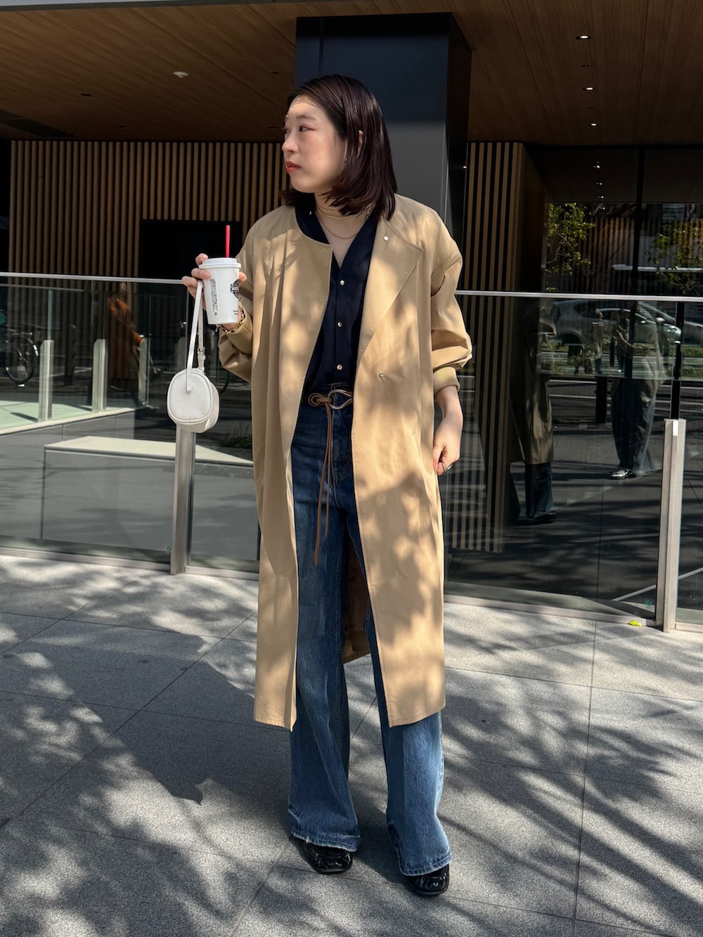 ブルー系のデニムパンツ、イエロー系のその他アウター、ブルー系のシャツ/ブラウスを着用したレディースの春コーディネートの3枚目の写真